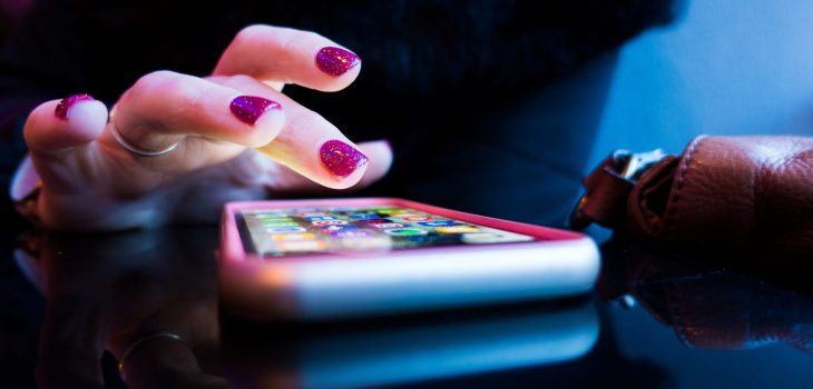 person using black smartphone with gray and pink case