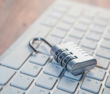 A combination lock rests on a computer keyboard.