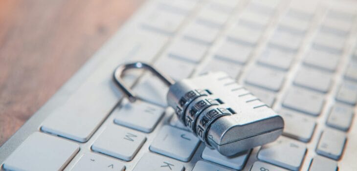 A combination lock rests on a computer keyboard.