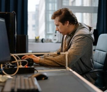 Free A concentrated professional working at a computer in a modern office setting. Stock Photo