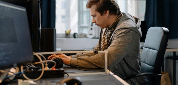 Free A concentrated professional working at a computer in a modern office setting. Stock Photo