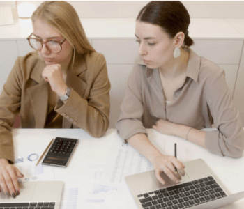 two women with laptops